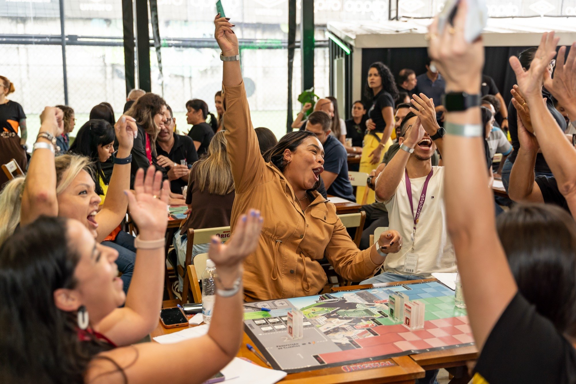 Participantes comemorando durante um workshop com dinâmica de vendas